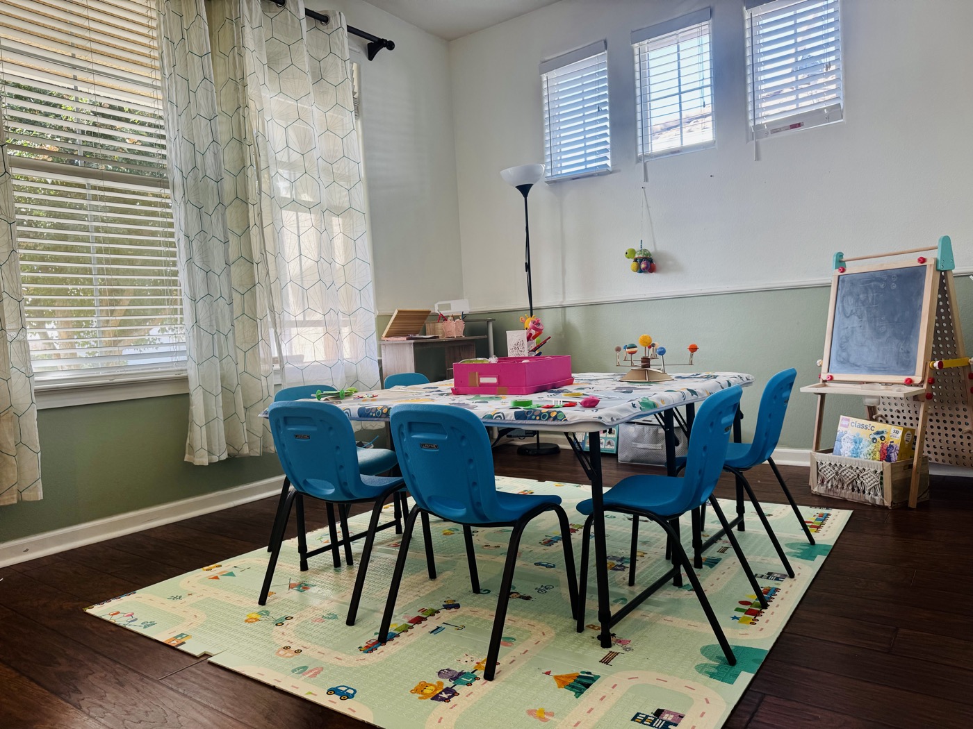Sunlit CosmoSprouts classroom with a project table and blue chairs
